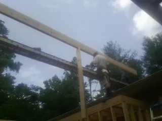 Carpenter setting a ridge beam over a new addition frame — Ice Dam Removal by Roofing Brothers in Fitzwilliam