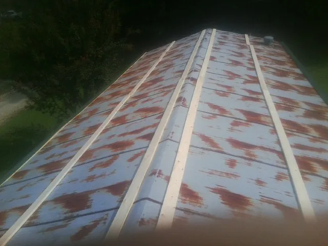 Rusted metal roof panels with new wood purlins before replacement — Storm Damage Roof Repair in Fitzwilliam by Roofing Brothers