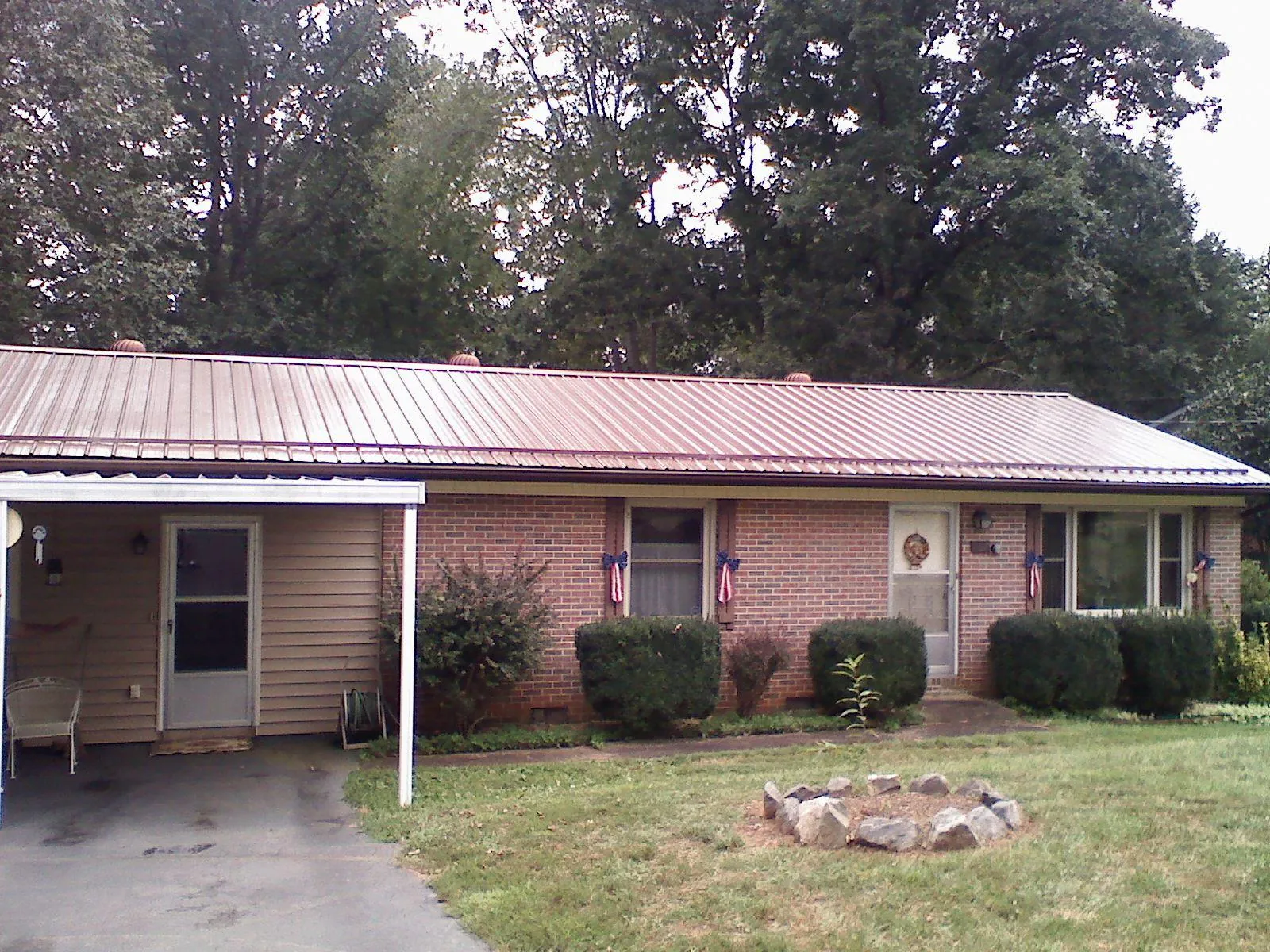 Bronze metal roof and carport on a brick ranch home — Roof Repair work by our crew in Fitzwilliam